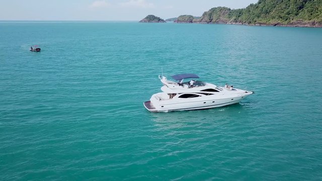 Drone aerial footage of luxurious motor yacht, camera turning around the boat