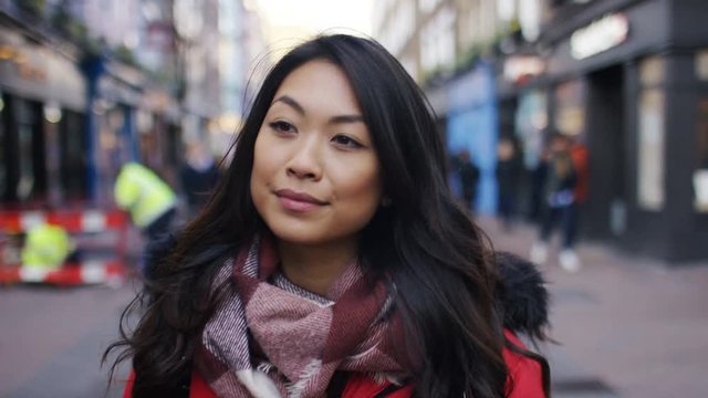 Attractive young female walking through a high street, in slow motion