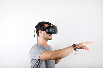studio shot of a young, male model playing with virtual reality (VR) headset