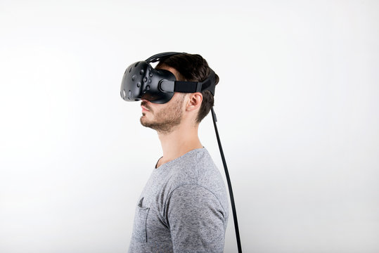 studio shot of a young, male model playing with virtual reality (VR) headset