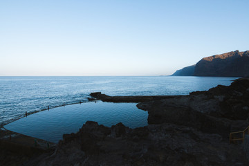 Calm water in natural pool near ocean at dawn