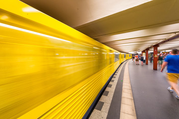 BERLIN, GERMANY - JULY 23, 2016: Yellow subway train speeding up on a city station. Berlin attracts...