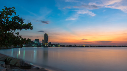 Twilight sunset in the public park near the beach, reflect water, city night background.