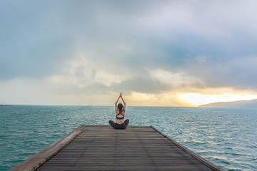 Healthy woman lifestyle balanced practicing meditate and energy yoga on the wood bridge in morning the beach. Healthy Concept.. - obrazy, fototapety, plakaty