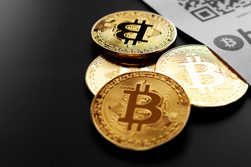 Bitcoin golden coins and paper receipt isolated on a black background