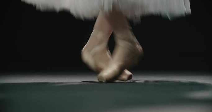 close-up footage, ballerina's feet in pointe shoes during performance of classical ballet elements