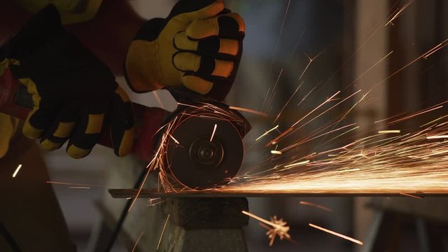 Construction worker grinding metal and making sparks, closeup