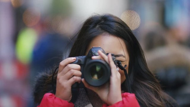 Attractive young asian female taking photos with a camera of the viewer
