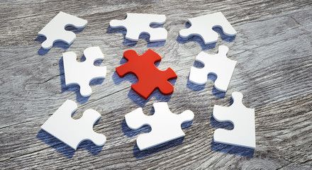 Puzzle-Teile in Weiß und Rot auf Holz 