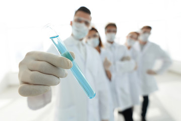 background image is a group of medical workers working with liquids in laboratory