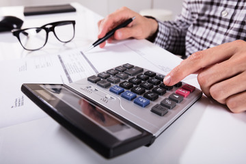 Businessman's Hands Calculating Invoice