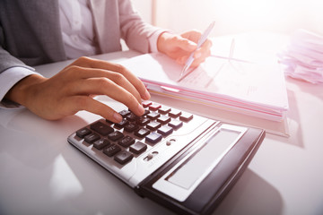 Businessperson Calculating Bills In Office