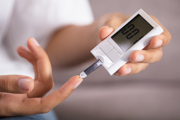 Person Checking Sugar Level With Glucometer