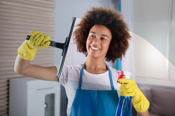 Woman Cleaning Glass Window With Squeegee