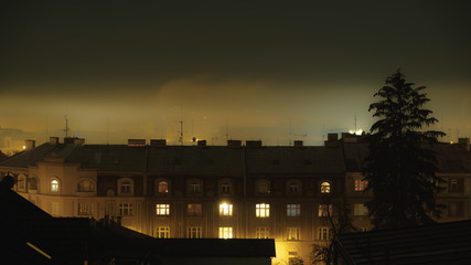 night setting upon old  buildings on a foggy day