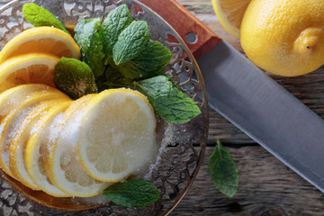 Lemon slices with sugar and mint leaves.
