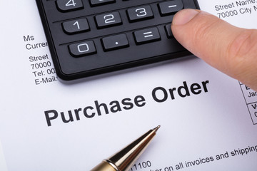Person Using Calculator On Purchase Order Form