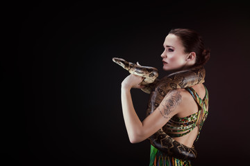 Jolie jeune femme ayant un boa constrictor sur son épaule