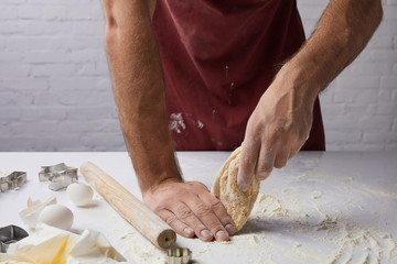 cropped image of chef preparing dough in kitchen