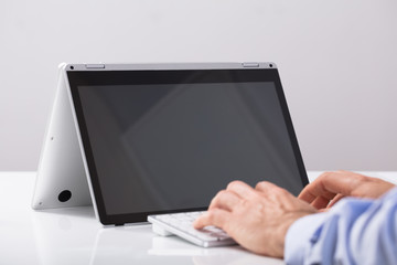 Man's Hand Typing On Hybrid Laptop