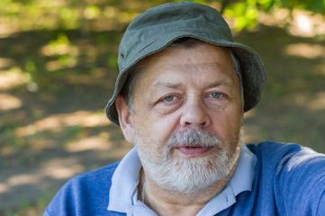 Portrait of Caucasian senior man delighting while making selfie outdoors