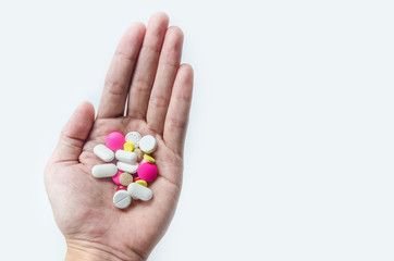 Top view of the pills on the hand and white background, A hand hold the pills and drug, Pile of the drug and pills on the hand.