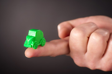 Finger mit kleinem grünem Auto