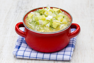Red saucepan with okroshka - traditional summer soup in Ukraine, Belarus and Russia. Close up