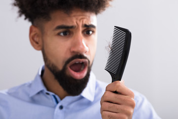 Man Looking At Hair Loss