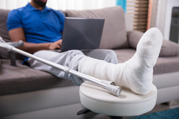 Man With Broken Leg Using Laptop