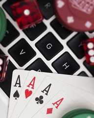 Online gambling. Playing cards, dice and betting chips on a computer keyboard