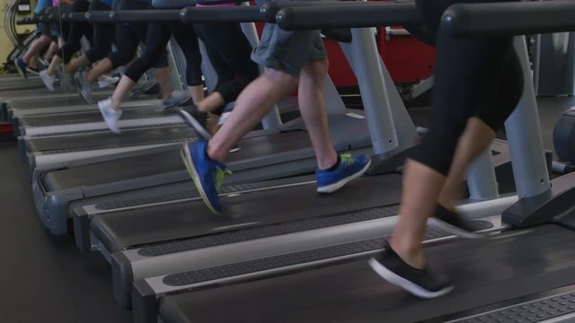 Closeup of feet running on treadmills at gym