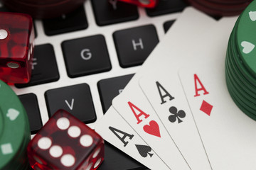Online gambling. Playing cards, dice and betting chips on a computer keyboard
