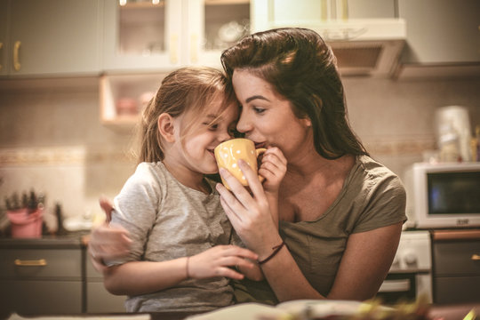 Mother and daughter have fun together. Mommy let me try coffee.