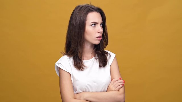 Young pretty girl suggests to reconcile over yellow background
