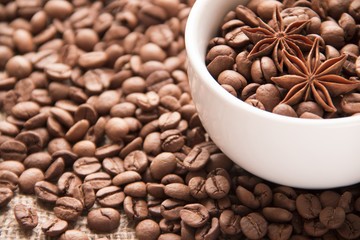 Coffee cup and coffee beans on burlap texture background. Top view with copyspace for your text