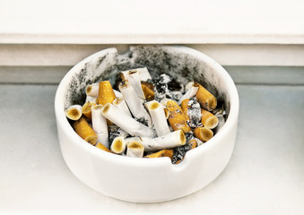 Heap of cigarette butts in a ashtray.