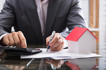 Businessperson Calculating Invoice With Calculator