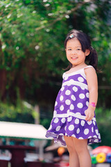 Little girl child showing front teeth with big smile: Healthy happy funny smiling face young adorable lovely female kid with new tooth dental loss: Joyful portrait of asian elementary school student