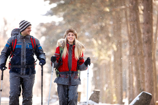 Male and female hikers walking in snowy nature