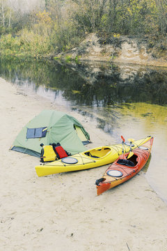Rafting on kayaks. A tent camp stands on the river bank.