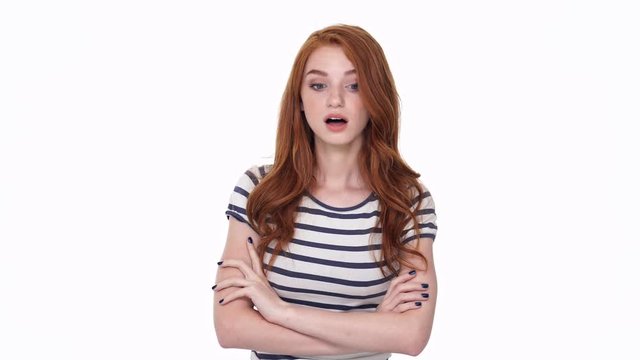 Displeased redhead young lady isolated over white wall background talking with you