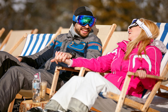 smiling man and woman enjoying together in sun at mountains