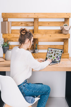 girl sitting at table with laptop with loaded pinterest page