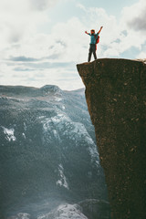 Man tourist success raised hands on Preikestolen cliff edge in Norway mountains Travel Lifestyle...