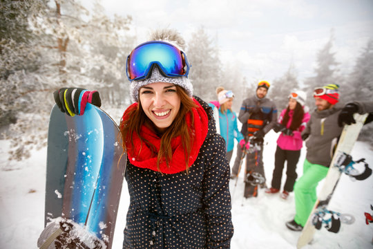 Sporty female holds snowboard in mountains on winter