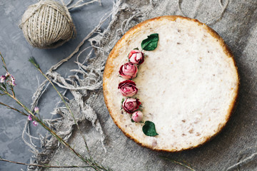 Pie from cottage cheese and bananas. Freshly baked cheesecake on rustic background. Decoration of dried flowers. Popular sweet dessert. top view.