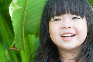 Little girl child showing front teeth with big smile: Healthy happy funny smiling face young adorable lovely female kid with new tooth dental loss: Joyful portrait of asian elementary school student