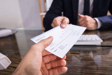 Businessperson Giving Cheque To Colleague