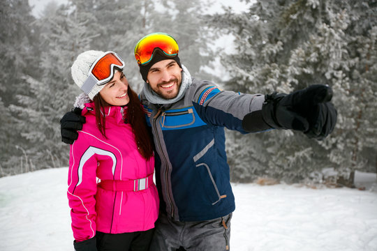 cheerful couple snowboarder enjoying at ski resort in the mountain